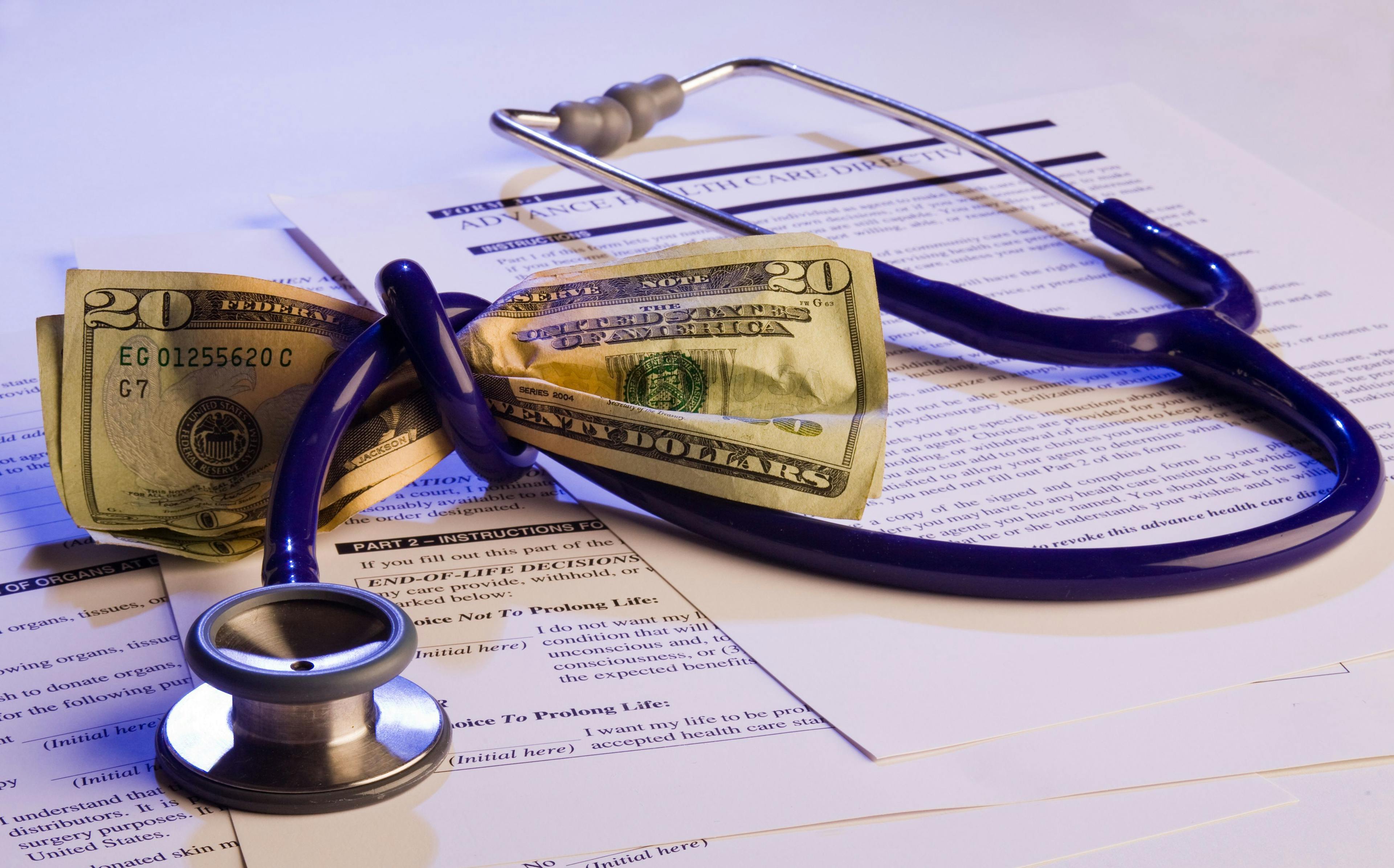 stethoscope wrapped around money with medical papers, money tied up in health care, medical expenses